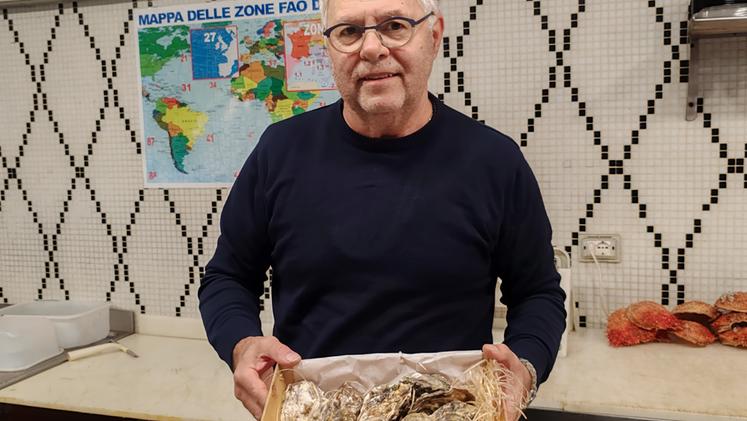 Il titolare della pescheria Claudio Perini con una cassetta di ostriche FOTO COLORFOTO