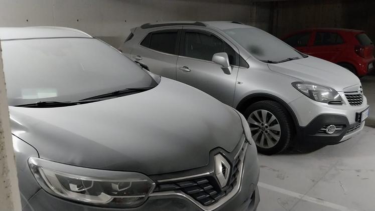Le auto in sosta nei posteggi interrati del centro di Schio coperte dalla polvere bianca (Foto R. Tognazzi)