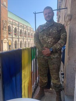 Orest Bardeha, con la divisa dell’esercito ucraino, vicino alla bandiera del suo Paese