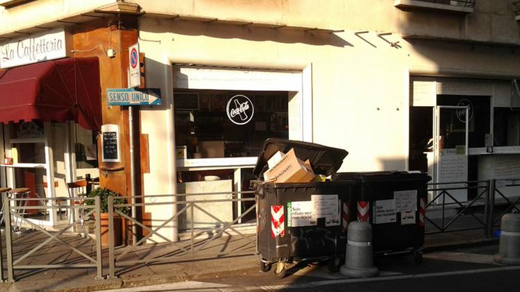 Il Rosy Bar a Vicenza con i cassonetti dei rifiuti davanti all'ingresso dove i clienti si bevono lo spritz