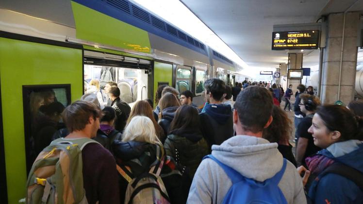 Un’immagine dei pendolari vicentini ammassati sui binari in attesa di salire sul treno. COLORFOTO