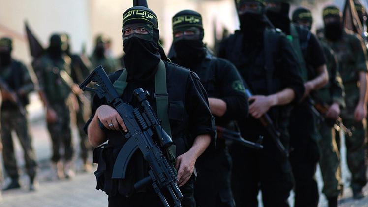 Miliziani dello Stato Islamico in parata con le armi e le lugubri divise nere del Califatto. ANSA
