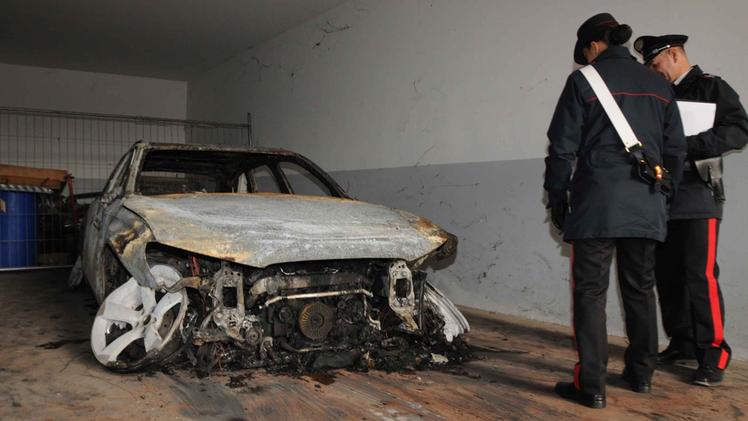La carcassa dell'Audi gialla bruciata dai banditi. ANSA