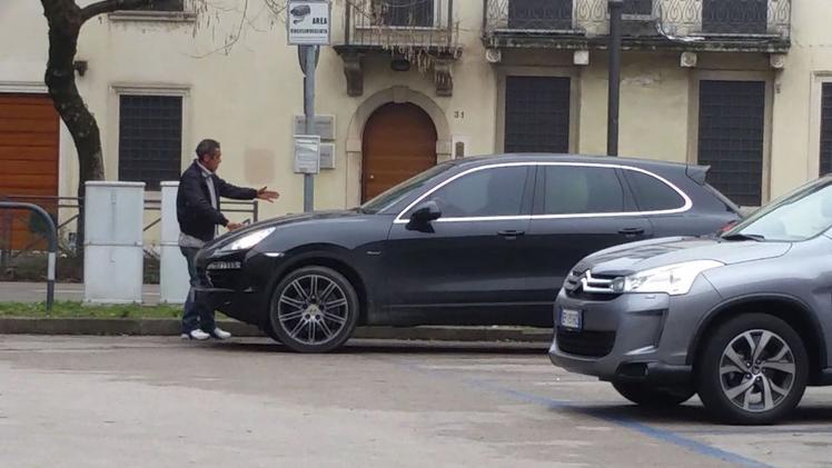 Il “boss” di piazza Matteotti mentre aiuta un automobilista a parcheggiare l’automobile nel piazzale 