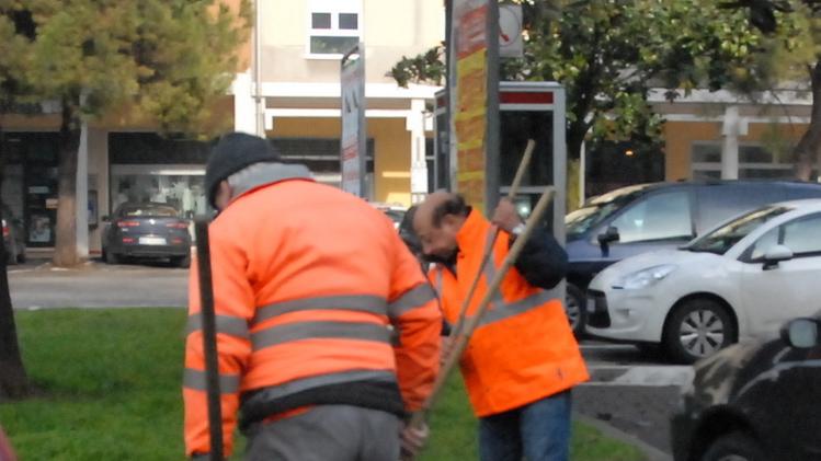 Lavoratori socialmente utili mentre puliscono le strade. ARCHIVIO