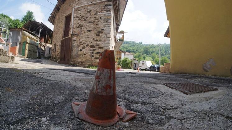 Un “birillo” avvisa del pericolo per la presenza di uno dei buchi nell’asfalto in contrada Lora di Sotto. K.Z.