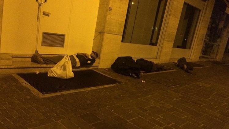 Qui sopra e a sinistra alcuni senzatetto che bivaccano da qualche notte lungo viale Roma