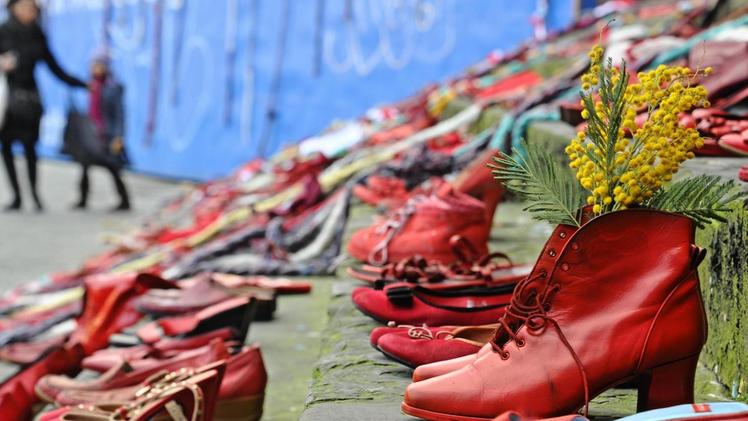 Il simbolo delle scarpe rosse in una piazza per dire no alla violenza sulle donne. FOTO ARCHIVIO