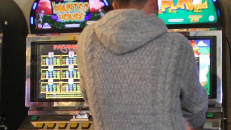 Un giocatore di slot machine in un angolo del locale pubblico.  ARCHIVIO