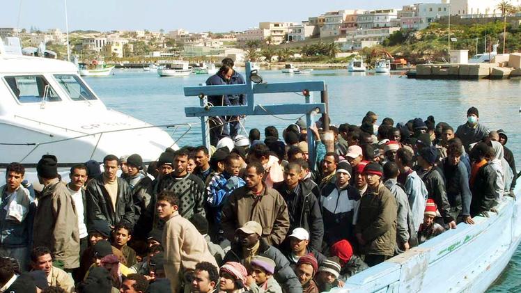Un’automobile ferma lungo la regionale 11 accostata ad una lucciola. FOTO ARCHIVIOUn barcone di immigrati nelle acque dell'isola di Lampedusa