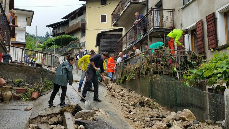 Volontari al lavoro per ripulire la contrada e le abitazioni dal fango e dai detriti
