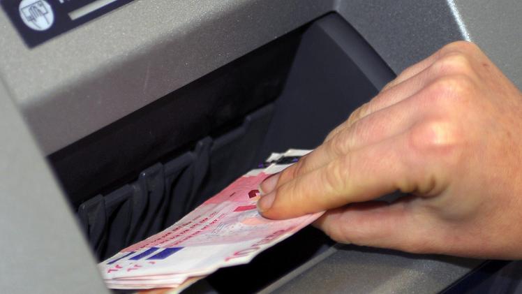 Un prelievo di banconote ad uno sportello bancomat