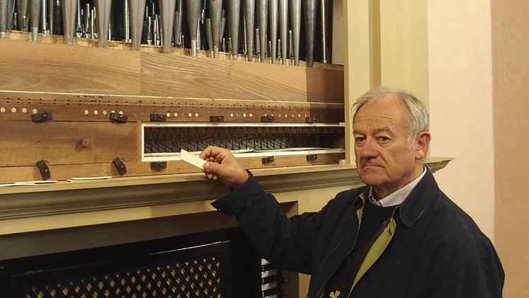 Don Sigfrido Crestani accanto all'organo danneggiato