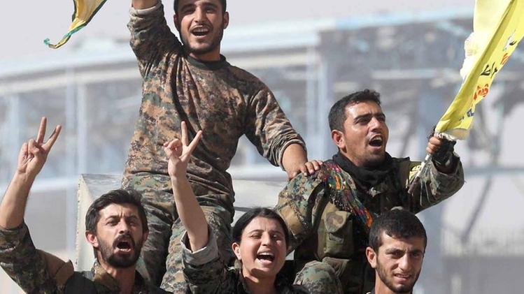 Due combattenti delle Forze democratiche siriane si fanno un selfie all’interno dello stadio di Raqqa. L’ormai ex  capitale dello Stato Islamico è stata conquistata ma l’Isis non può ancora dirsi sconfitto. ANSA/AP PHOTO/ASMAA WAGUIHI combattenti delle Forze democratiche siriane entrano a Raqqa