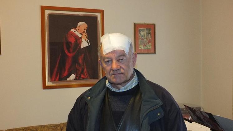 Don Sigfrido Crestani, 69 anni, con la vistosa fasciatura sulle ferite. MAZZARETTO