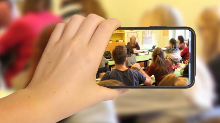 Un’insegnante filmata con un telefonino in classe in una foto d’archivio