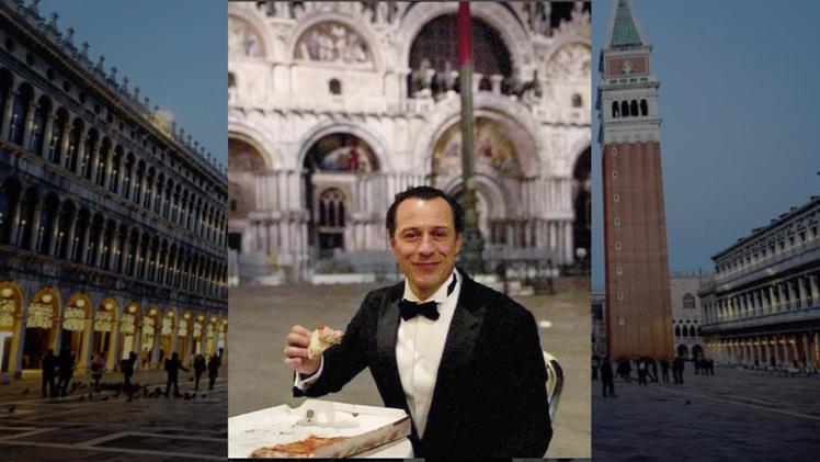 Stefano Accorsi mentre mangia la pizza sul cartone in piazza San Marco