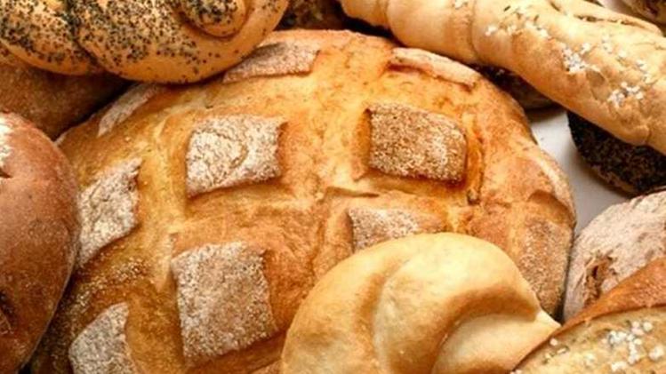 Alcuni tipi di pane fresco e, sotto, il presidente Ruggero Garlani