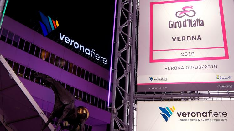 Il palazzo di Veronafiere colorato di rosa, dal piazzale partirà l’ultima tappa del Giro d’Italia 2019. La cronometro si concluderà in Arena