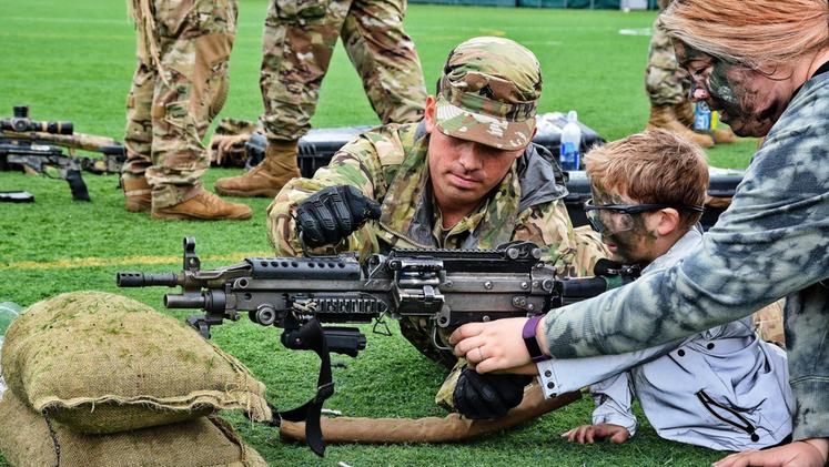 Un ragazzino, aiutato dai militari americani, impara a sparare al “Paratrooper for a day”