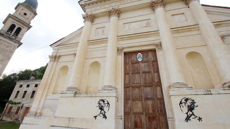 Le due figure disegnate dai vandali sulla facciata della chiesa. FOTO STUDIO STELLA