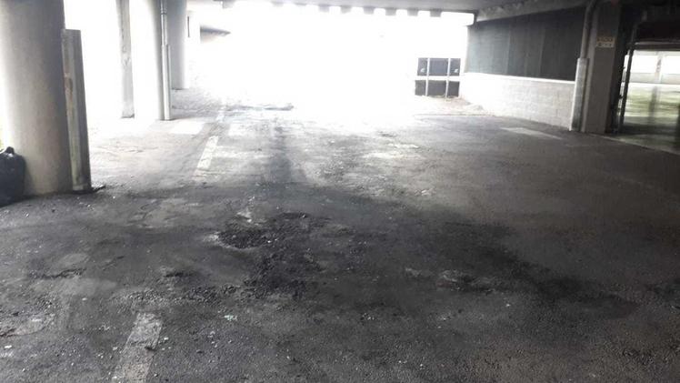 I segni dell’auto incendiata presenti sull’asfalto del parcheggio interrato.  MA.CA. L’ingresso del parcheggio sotto il complesso commerciale.  MA.CA.