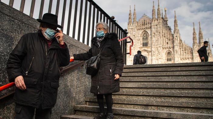 Persone con le mascherine davanti al Duomo (Foto Ansa)