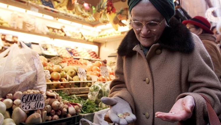 Un’anziana conta i centesimi prima di decidere cosa acquistare al supermercato. ARCHIVIO