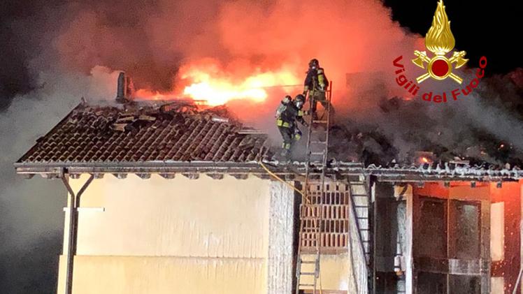 Le fiamme sul tetto dell'abitazione e i vigili del fuoco in azione