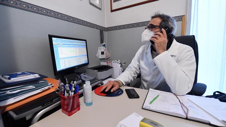 Un medico di famiglia dialoga con un paziente e gli prescrive la cura al telefono (Foto Ansa)
