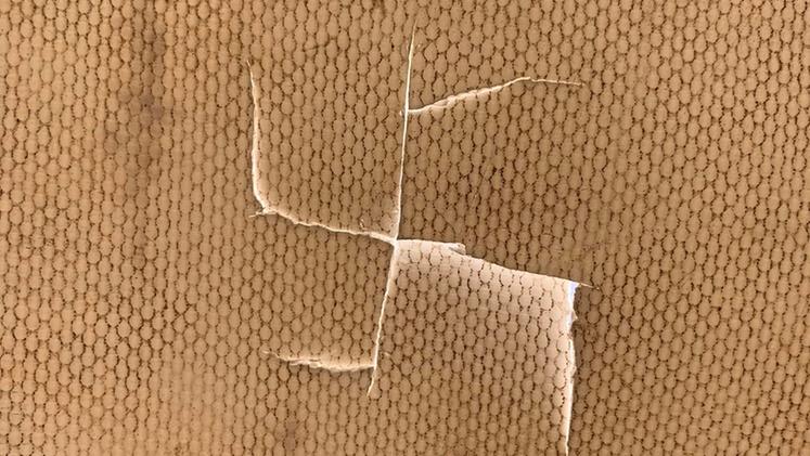 La traccia a forma di svastica lasciata con il taglierino sul tessuto