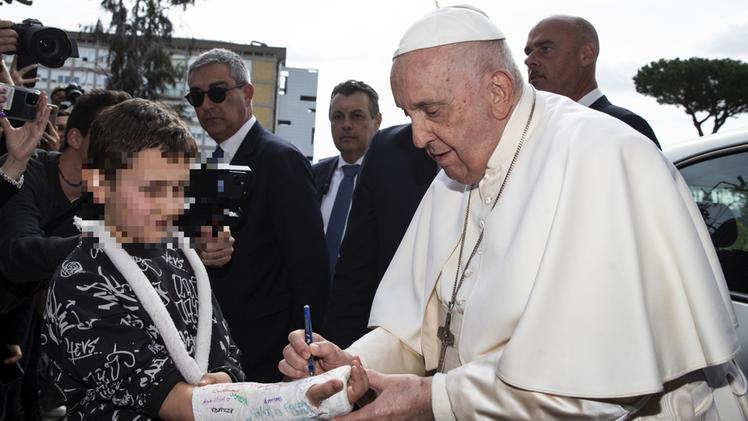 Il Papa firma il gesso di un bambino all'uscita dal Gemelli